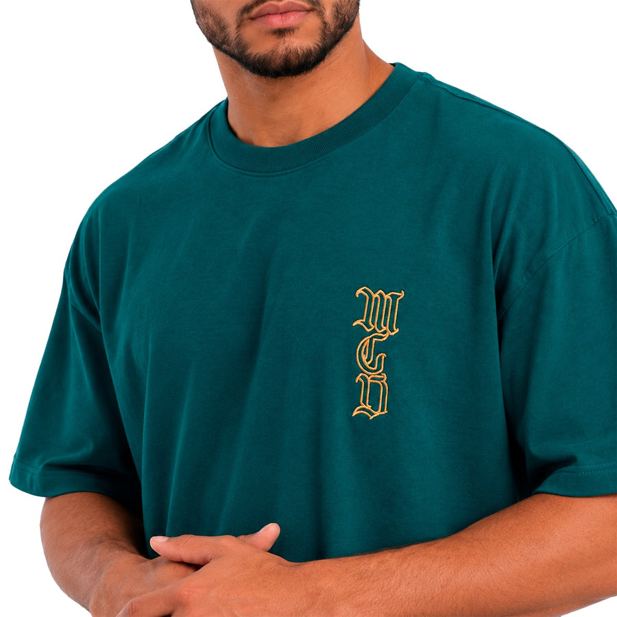 Camiseta Oversized Mcd Lateral Caligraffiti Masculino — Dourado sobre o verde-petróleo